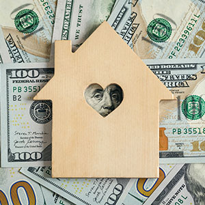 photo of money and wooden house cutout